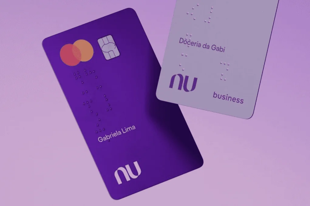 A imagem contém dois catões da marca Nubank, sendo um roxo e outro lilás claro, sob um fundo lilás mais escuro