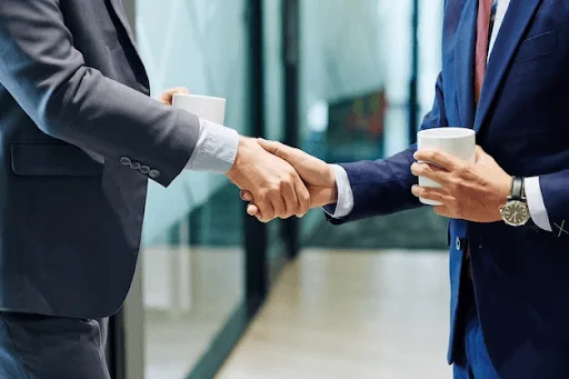 Bustos lateralizados de empresários apertando as mãos.