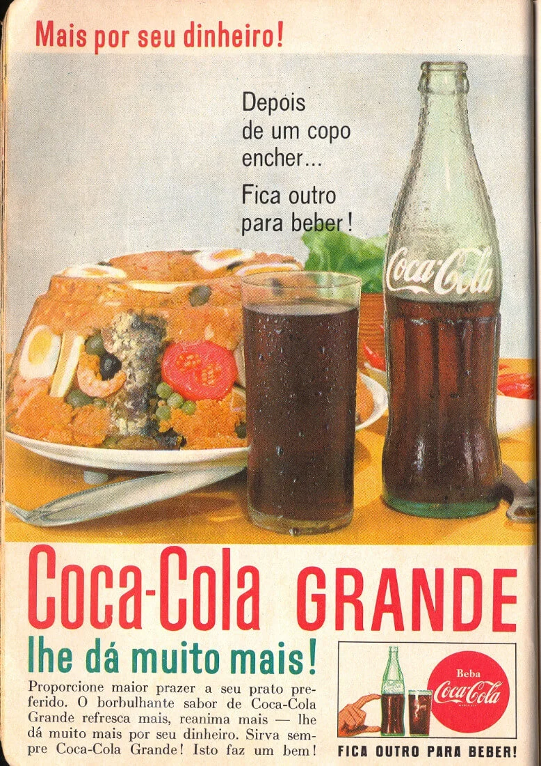 Anúncio da Coca-Cola dos anos 1960. Na foto, vê-se um copo cheio de refrigerante e uma garrafa pela metade, junto de um cuscuz paulista. O texto sobre a foto diz: “depois de um copo encher… Fica outro para beber!” O título do anúncio, por sua vez, é: “Coca-Cola grande lhe dá muito mais!”