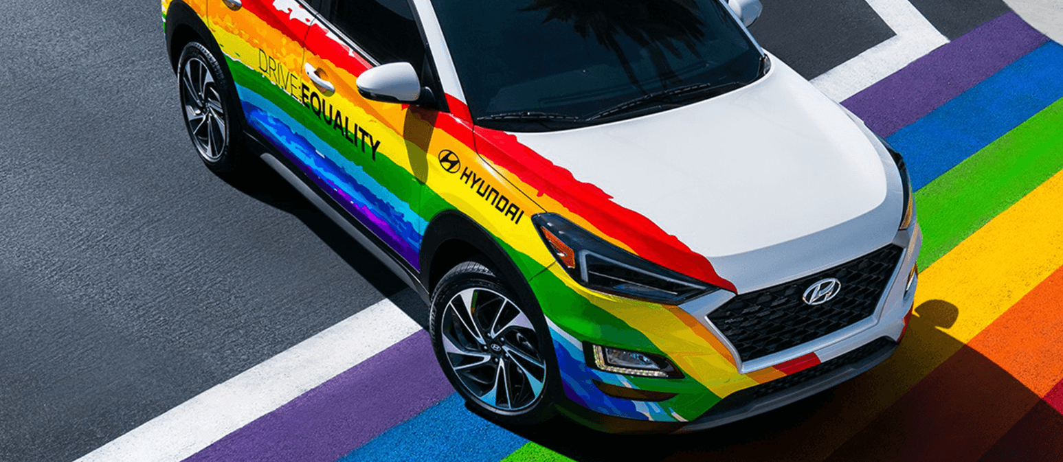 A imagem mostra um carro da Hyundai com as cores da bandeira da comunidade LGBTQIA+